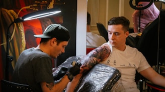 a man holding a gun next to a man with a hat