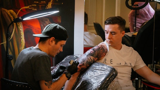 a man holding a gun next to a man with a hat