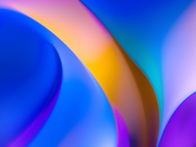 Abstract image with smooth, curved shapes in bold colors such as blue, purple, and yellow. The design exhibits a gradient effect with seamless transitions between colors, creating a sense of fluidity and motion.