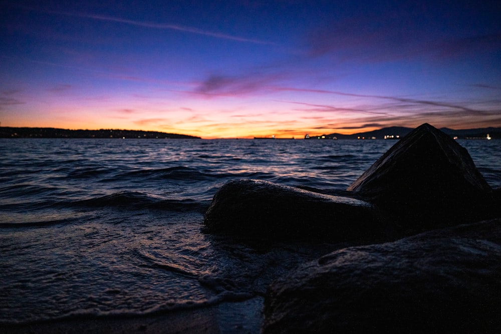 a rocky beach with a sunset