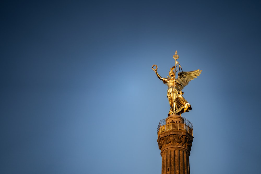 una statua dorata su un pilastro