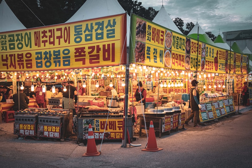 A vibrant photo of Seoul's bustling night market filled with colorful lights and street food stalls.