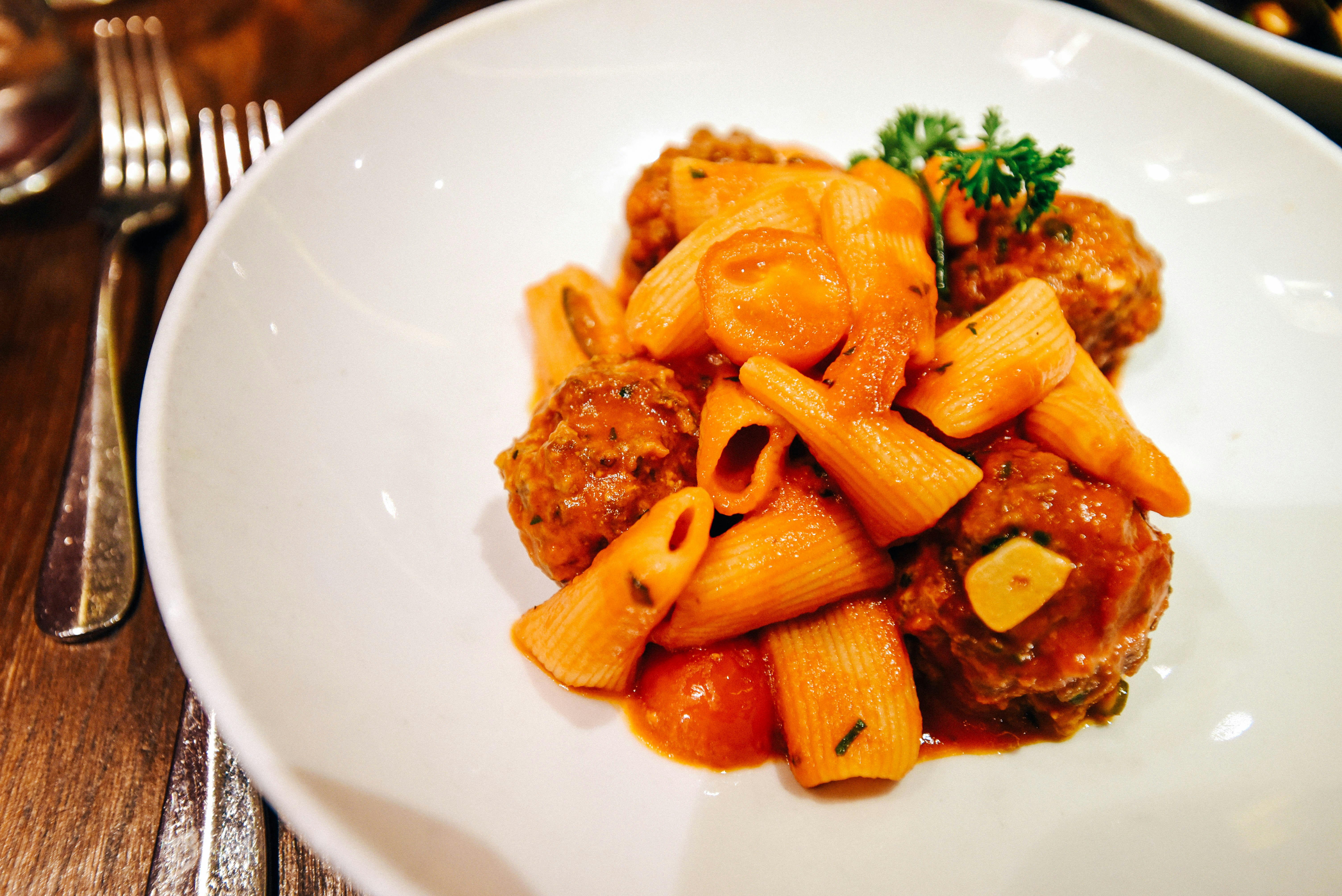 Juicy meatballs with tomato sauce on dark plate, restaurant lighting