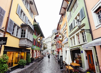 a person walking down a street lined with buildings