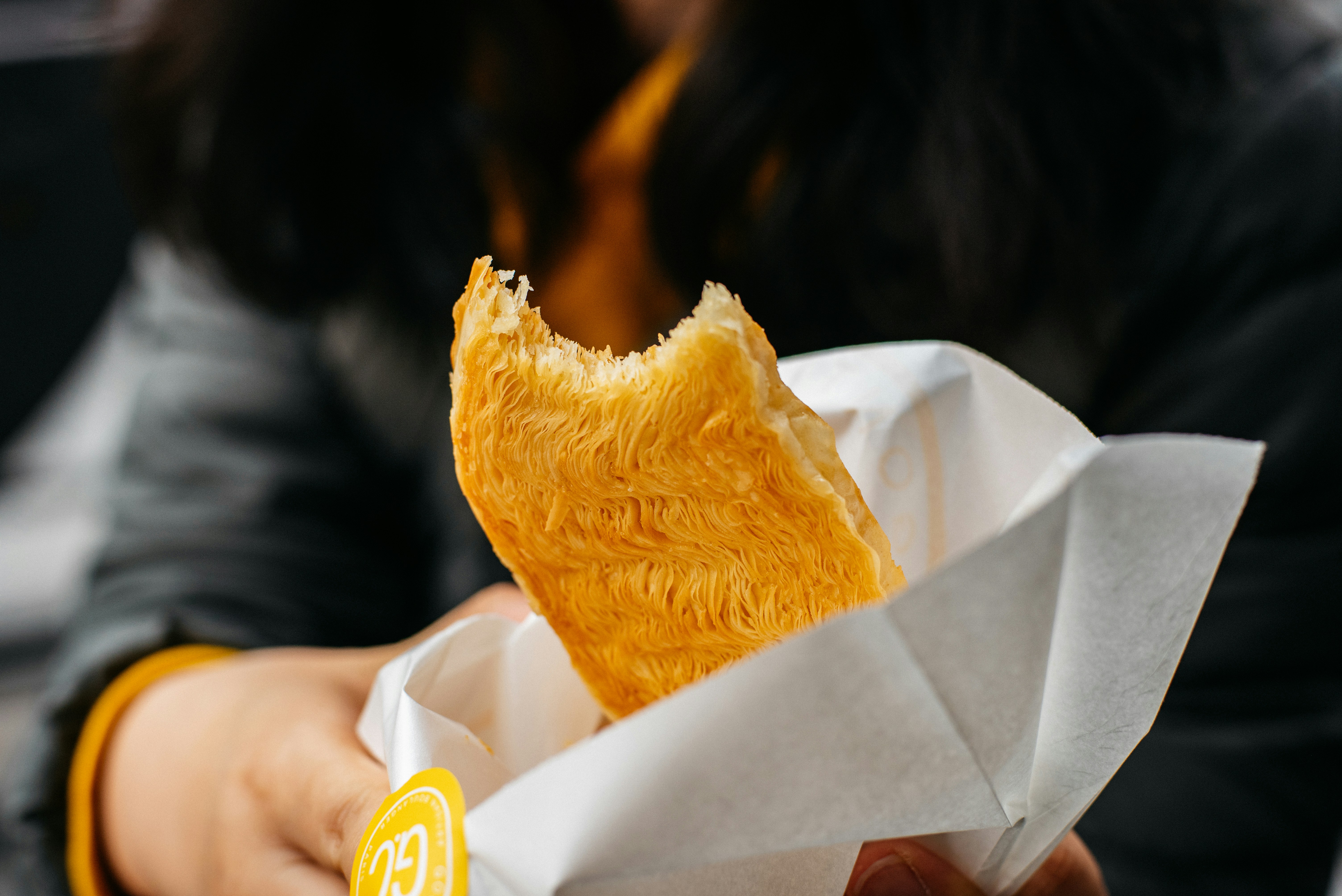 Hand holding a quesadilla in paper