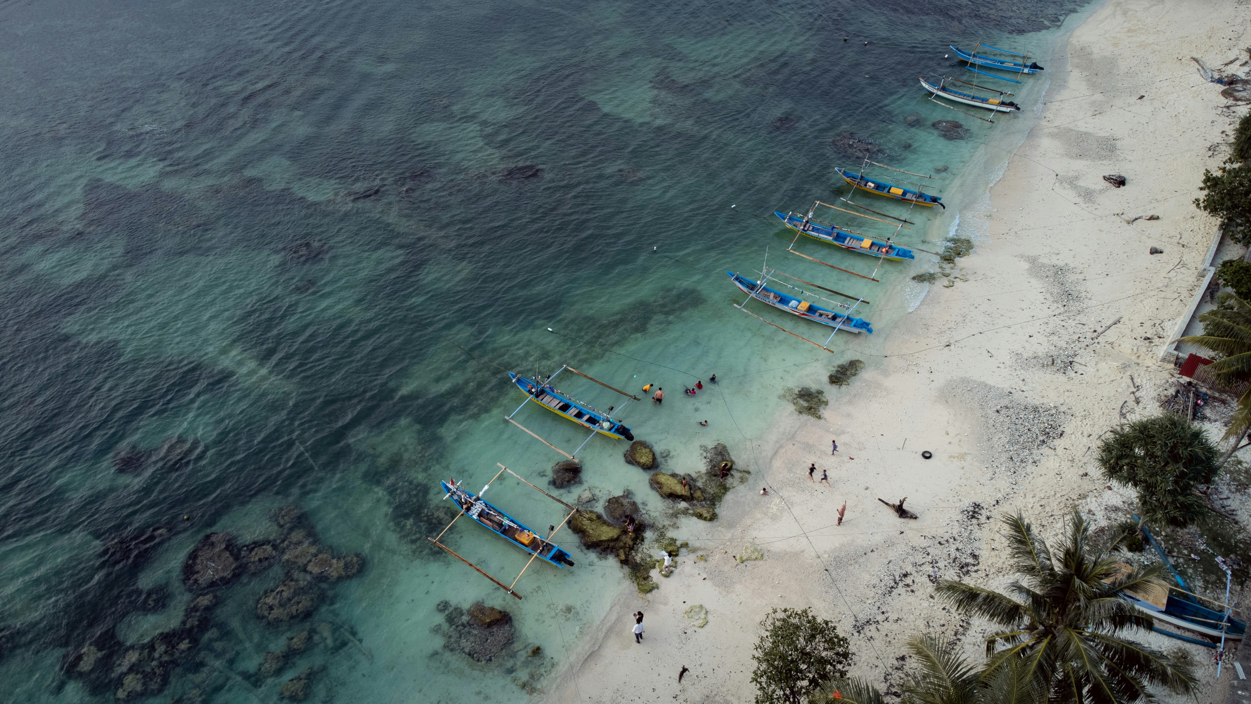 a beach with boats and people
