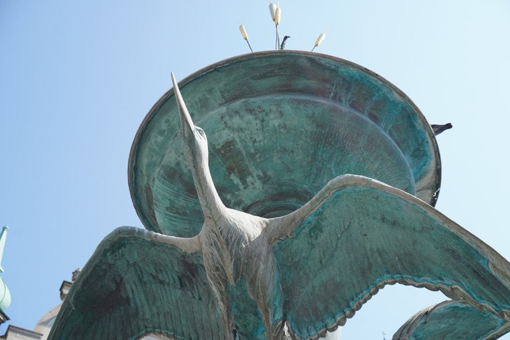 a statue of a person with a horn and a bird on top