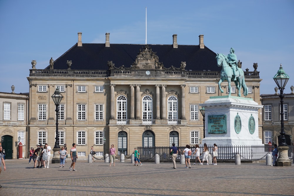 un gran edificio con una estatua frente a él con Amalienborg al fondo