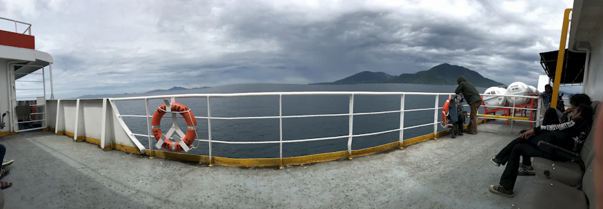 Passengers enjoying the deck of a modern ferry with panoramic sea views.