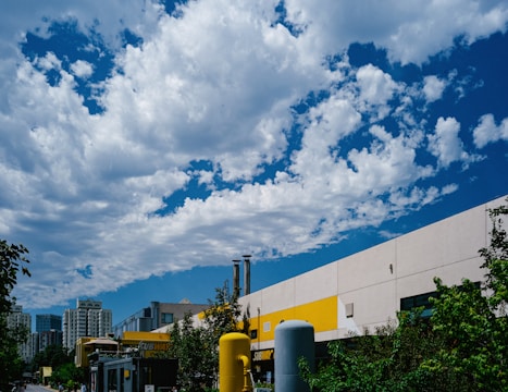 Industrial infrastructure blending with green spaces under a bright sky.