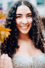 Close-up of soft, bouncy spiral curls framing a smiling young woman’s face.