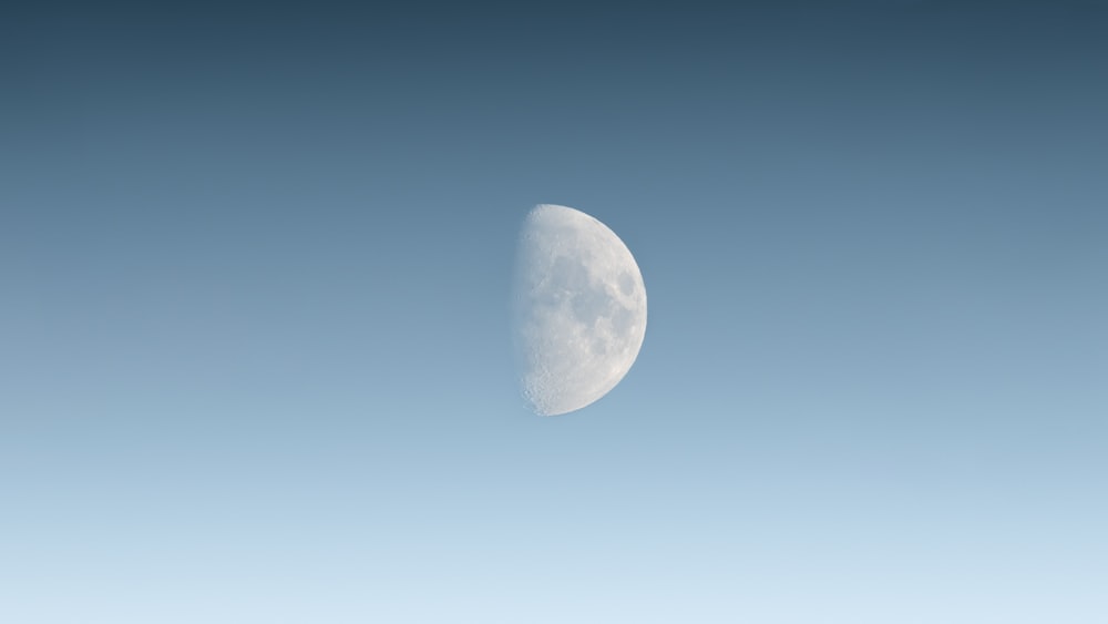 a half moon in a blue sky