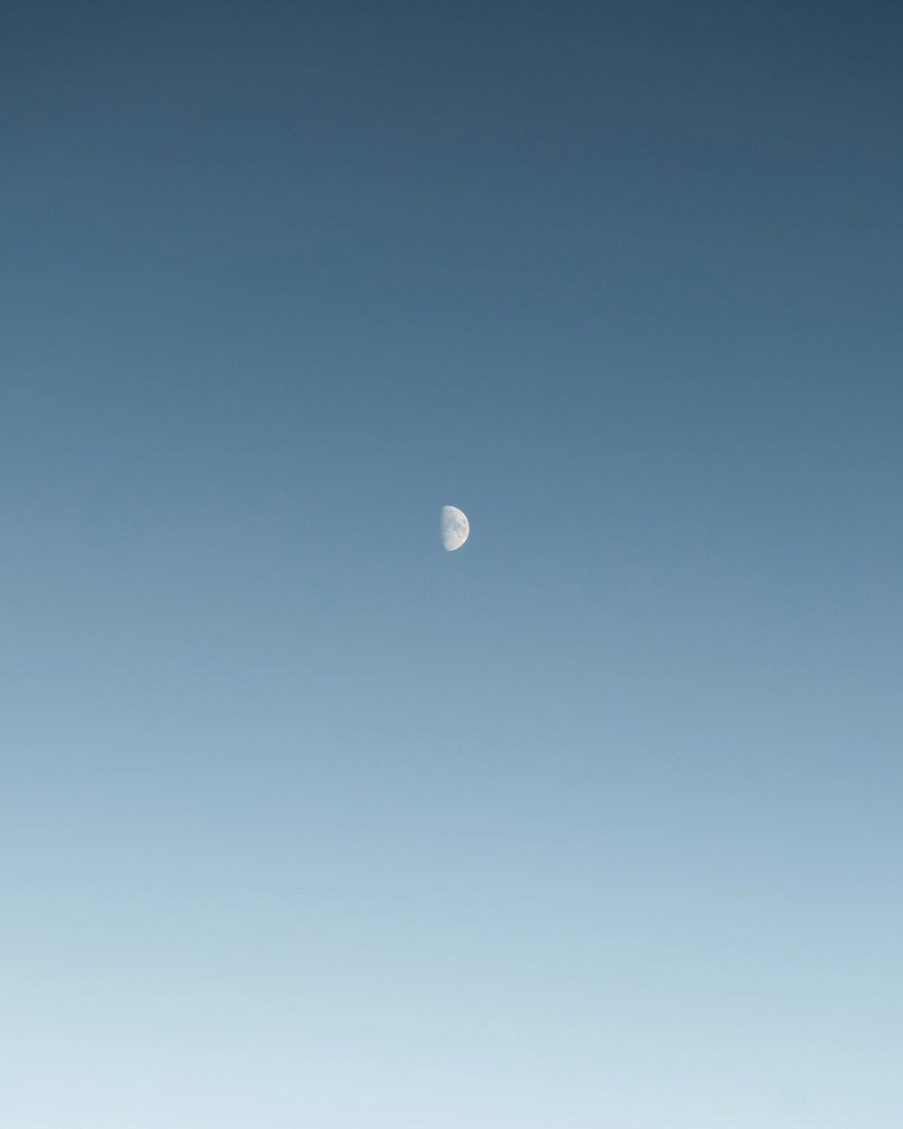 a half moon in a blue sky
