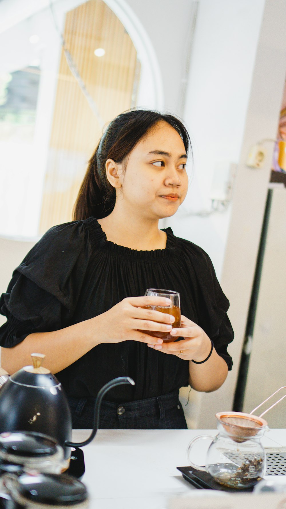 a person holding a glass of liquid