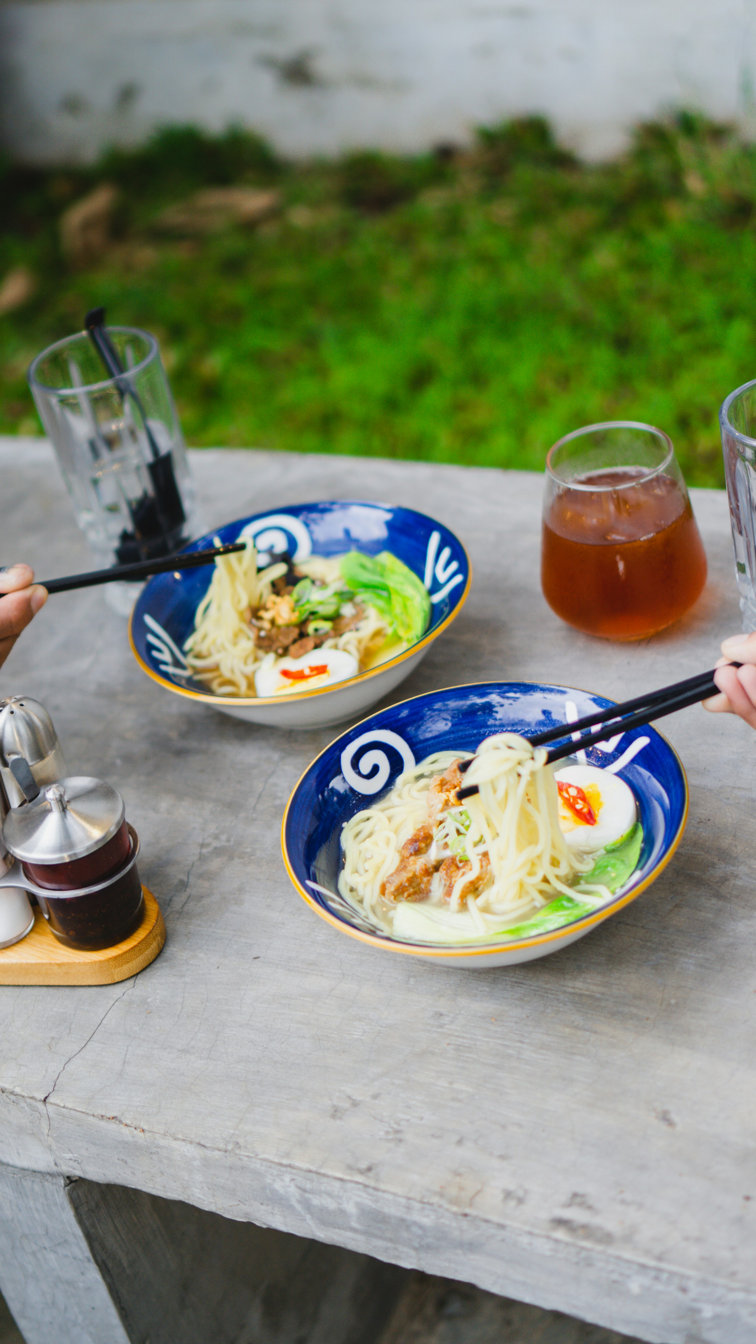 a table with plates of food and glasses of liquid