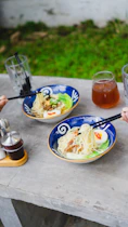 a table with plates of food and glasses of liquid