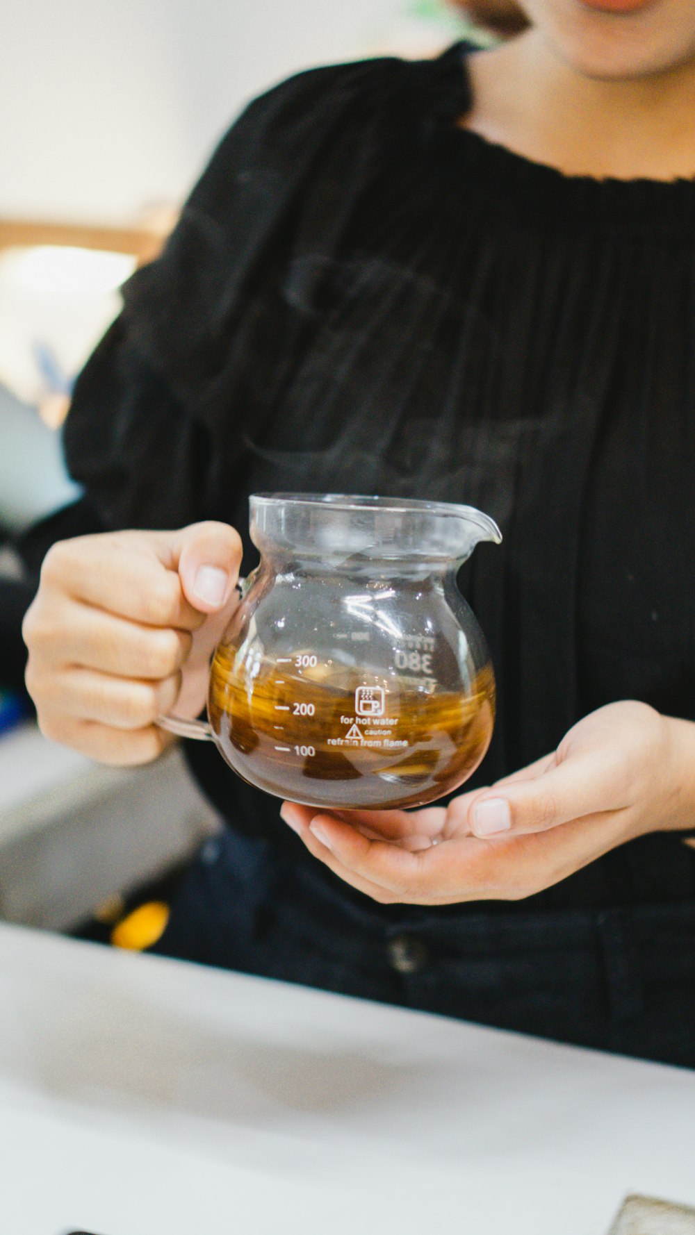 a person holding a glass of liquid