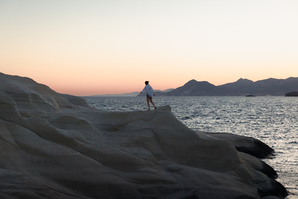 a man walking on a rocky beach
