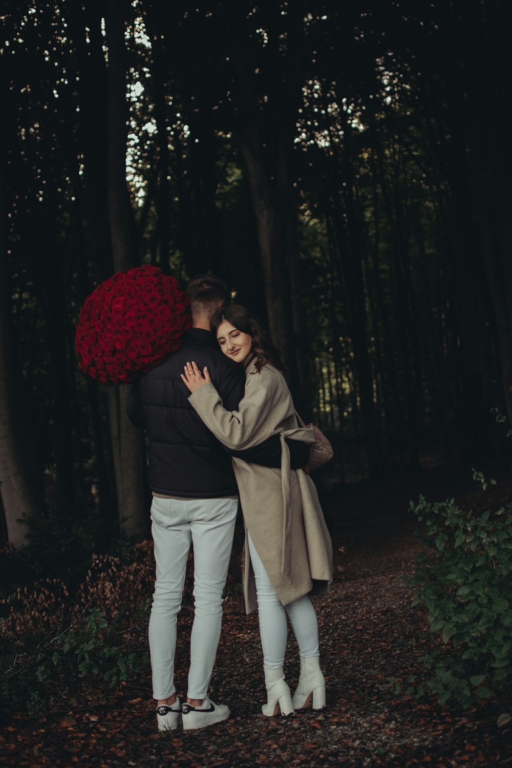 Un uomo e una donna che si baciano nel bosco