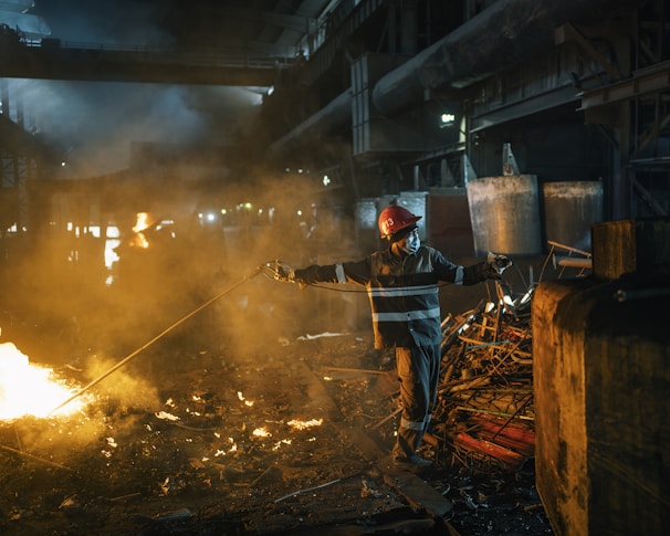 Technicians installing refractory lining inside a large aluminum melting furnace at an industrial plant