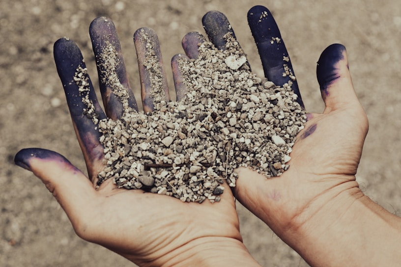 a hand holding a handful of dirt