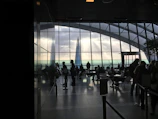 Joyful attendees connecting over coffee breaks with city skyline visible through floor-to-ceiling windows