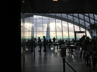 Joyful attendees connecting over coffee breaks with city skyline visible through floor-to-ceiling windows