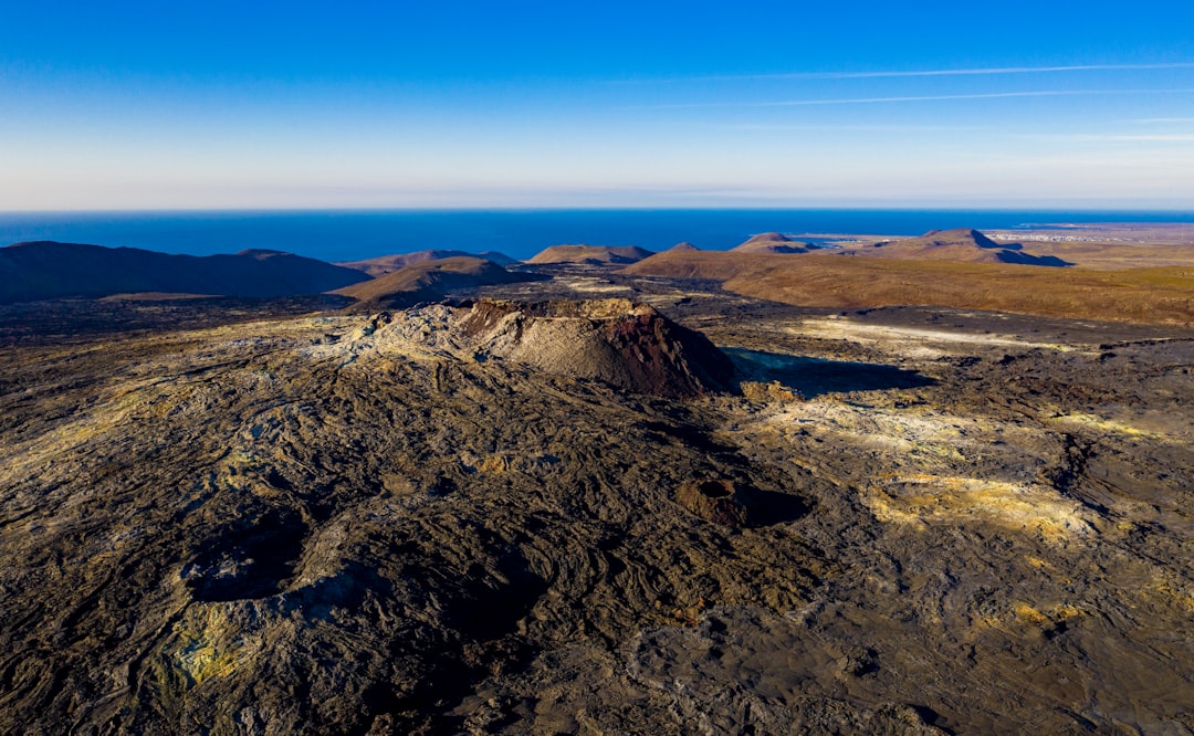 a landscape with hills and a blue sky,