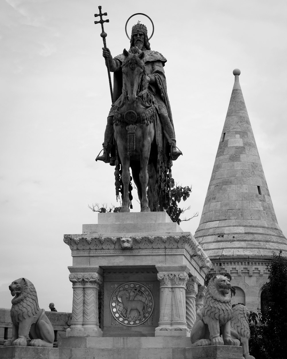 a statue of a person holding a cross and a dog