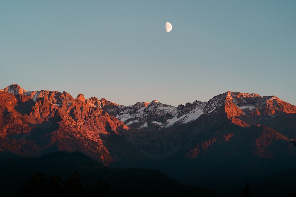 a mountain range with the moon in the sky