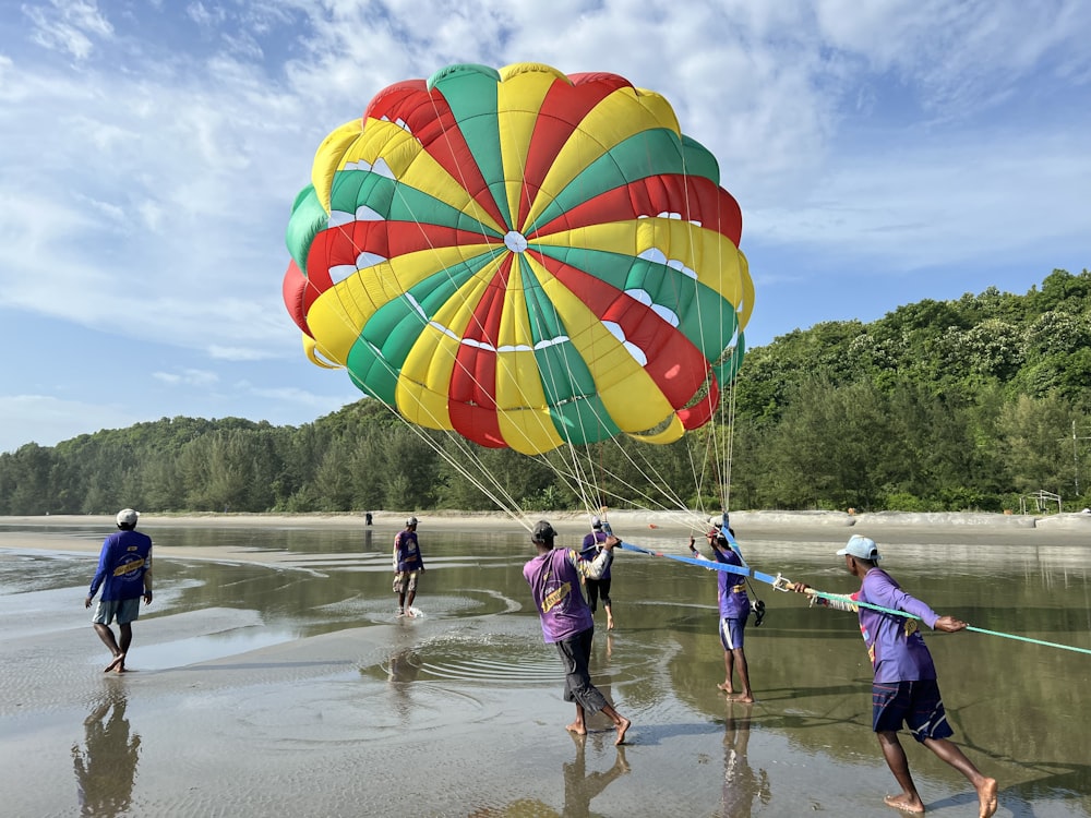 a group of people running in water with a parachute
