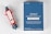 A red and gray injector labeled with the brand ZIMHI lies next to a blue box with printed text indicating it contains naloxone, used for opioid emergencies. The box provides dosage instructions and mentions it is for intramuscular or subcutaneous use.