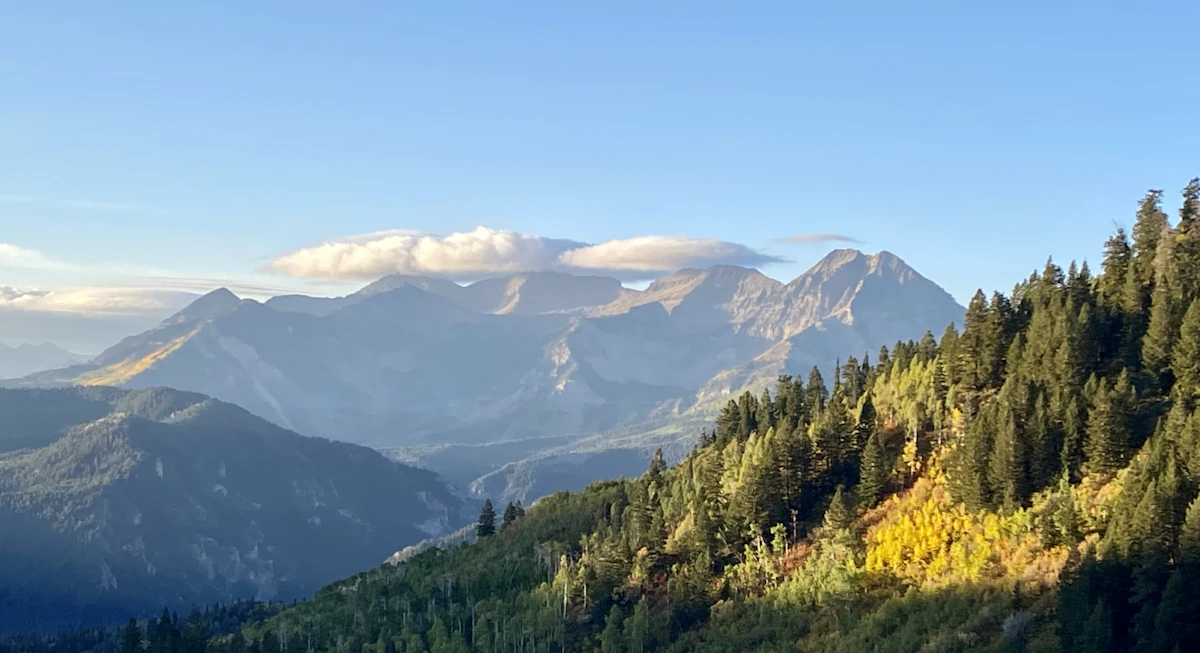 Morning clouds over high peaks, seen from autumn woods in American Fork Canyon