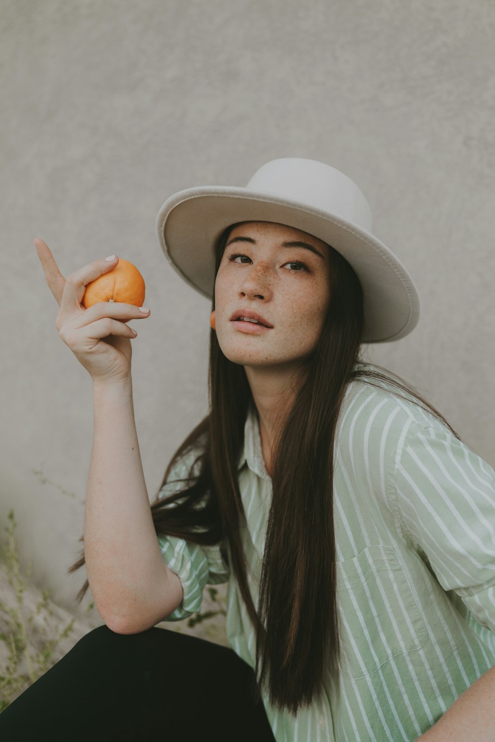 a person wearing a hat and holding a carrot