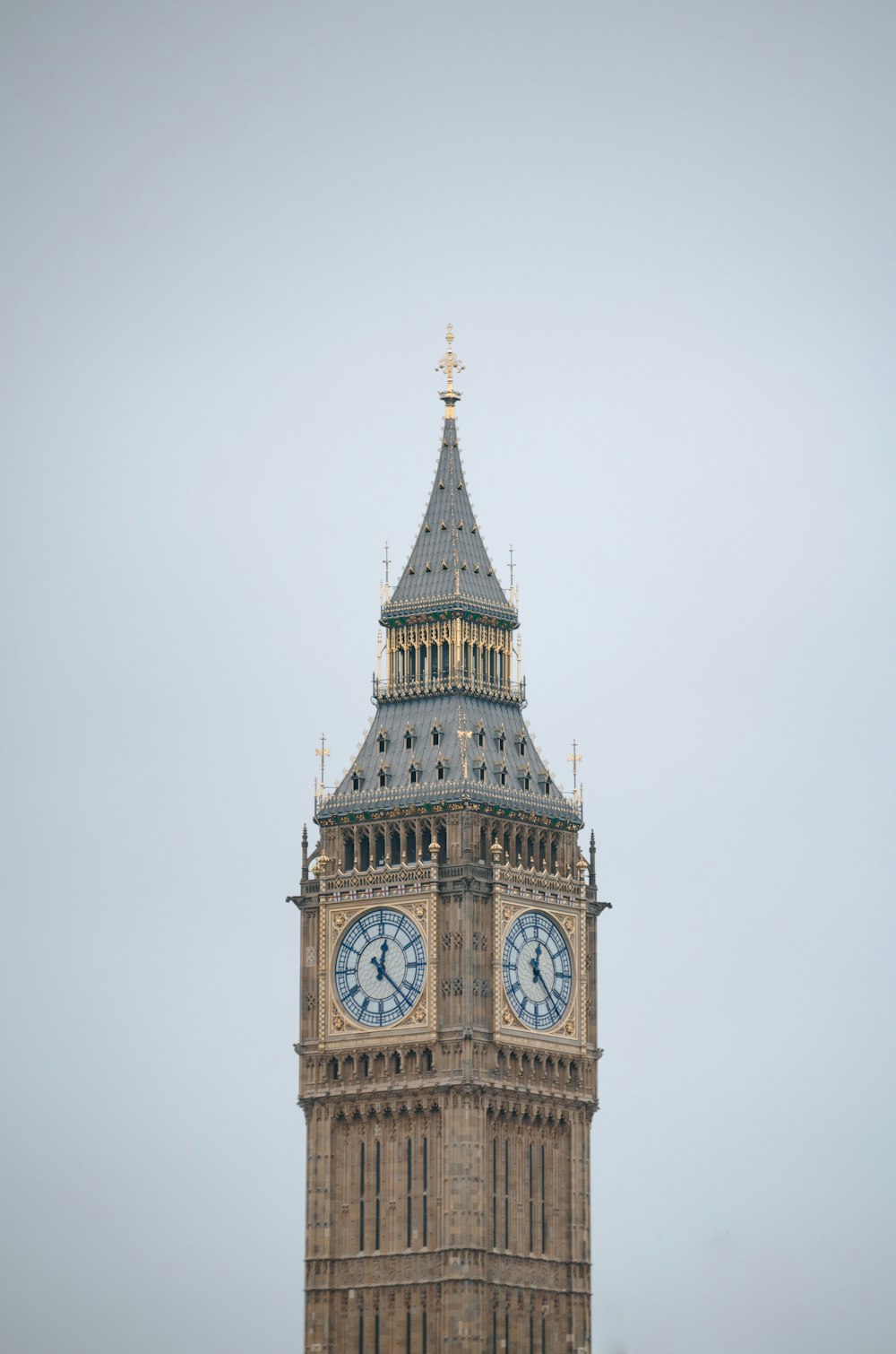 a clock tower with a weather vane with Big Ben in the background