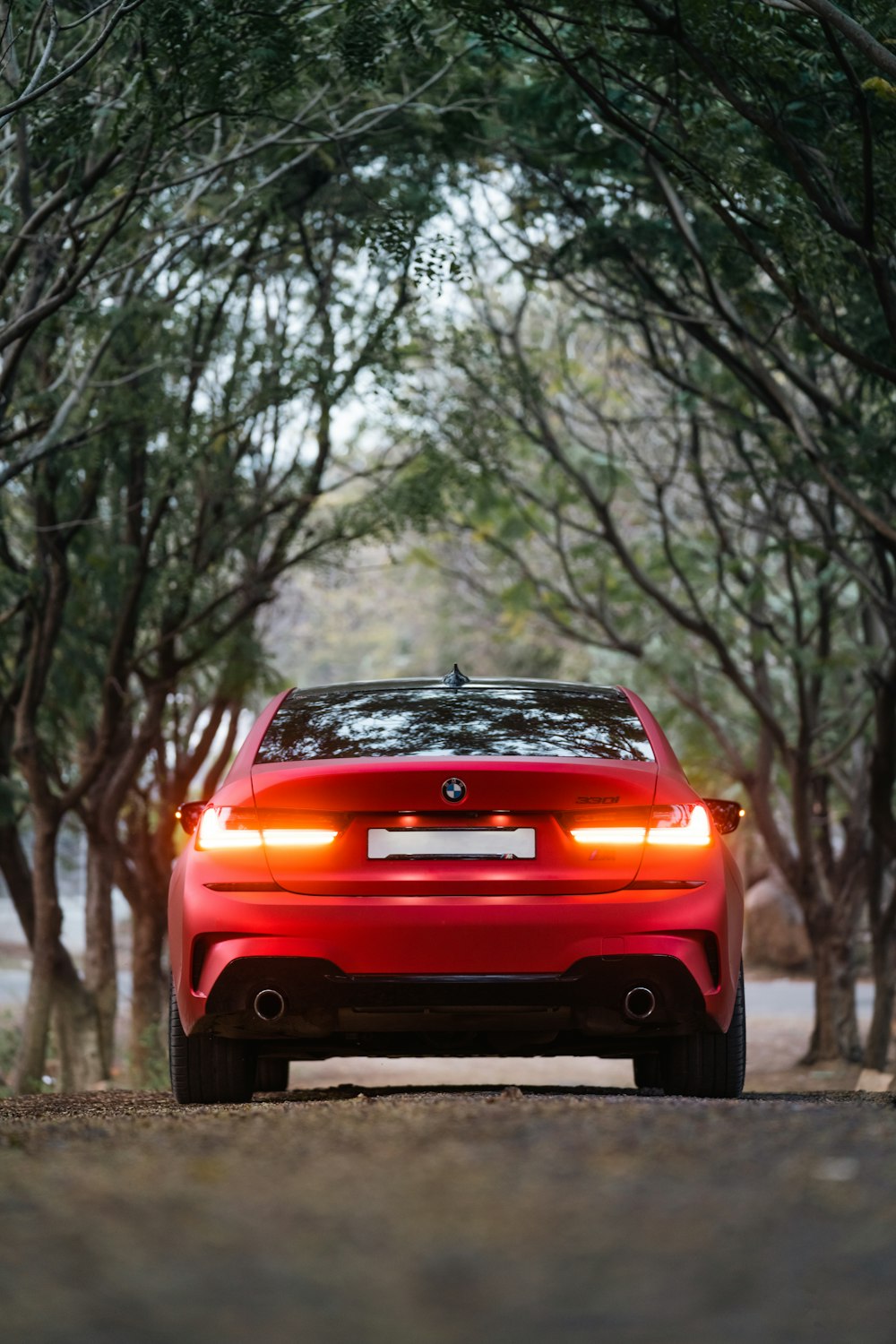 a red car parked in a wooded area