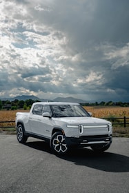 Red pickup truck parked on a rugged terrain under a dramatic sky.