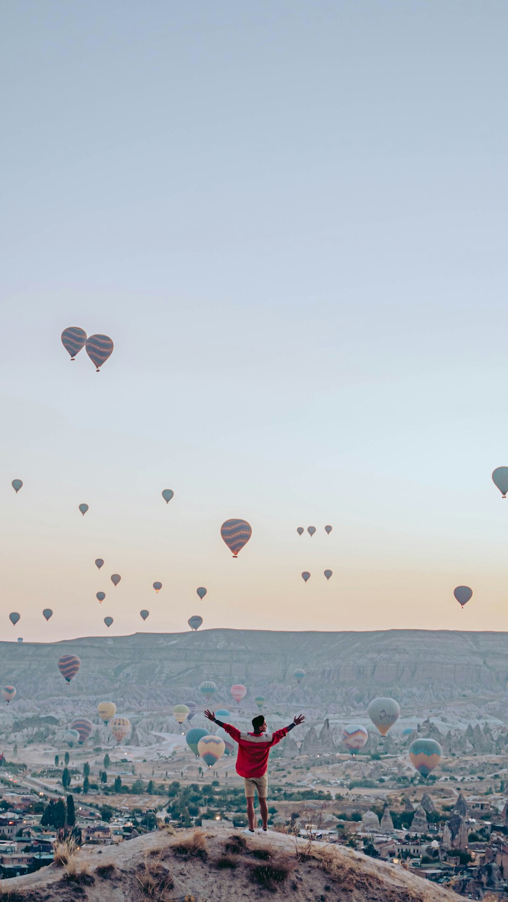 a person flying a large group of hot air balloons