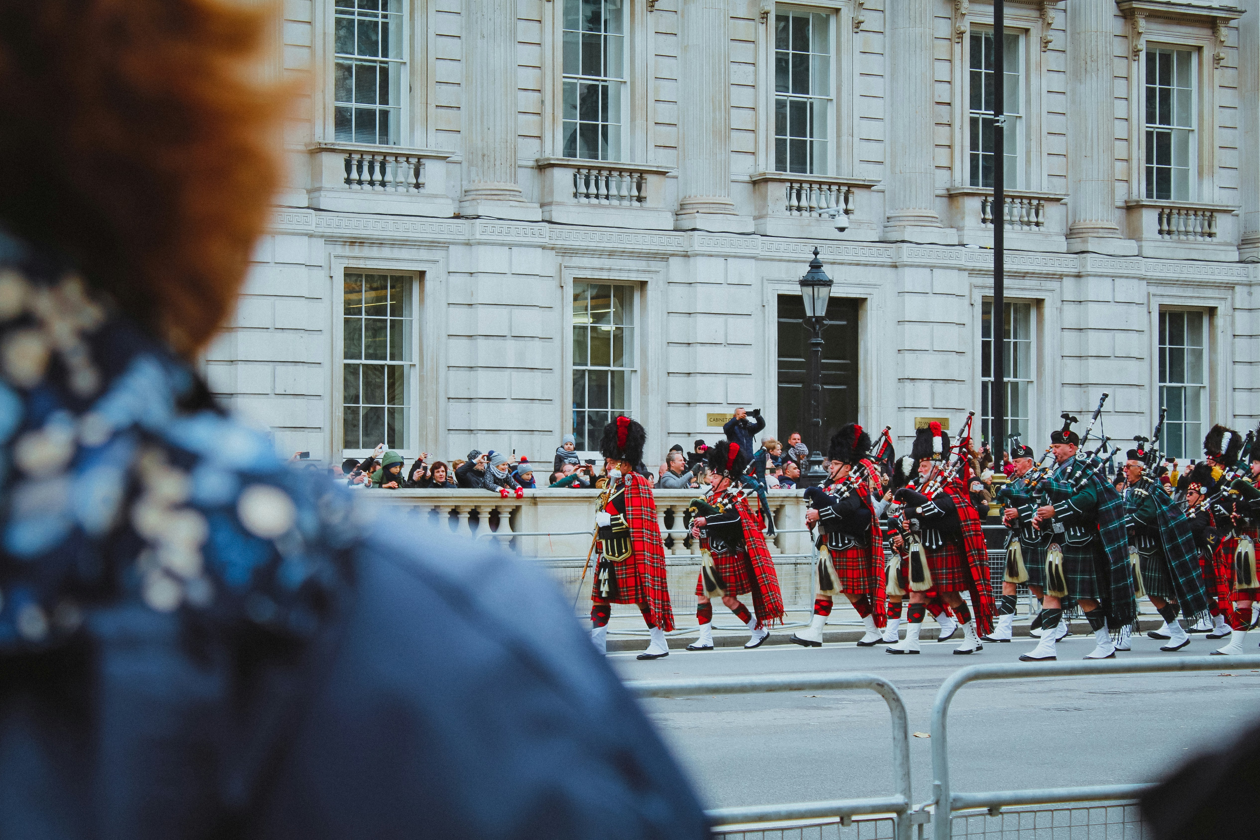 a group of people in red and black uniforms marching down a street