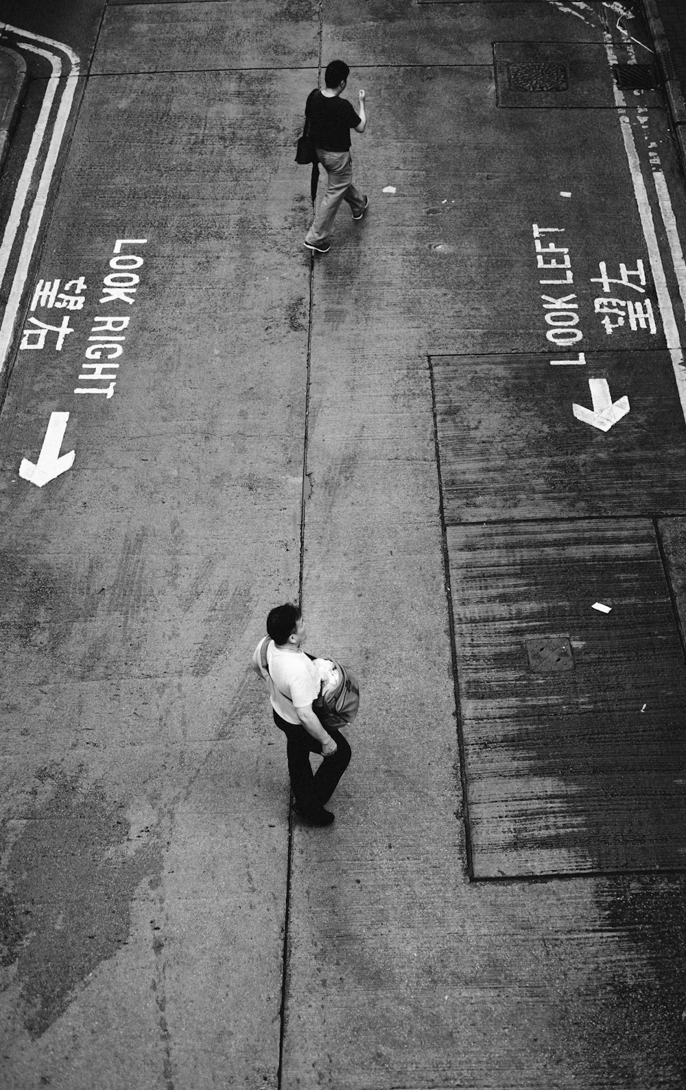 a couple of people walk down a sidewalk