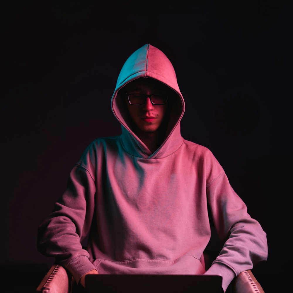 a man wearing a hoodie and glasses