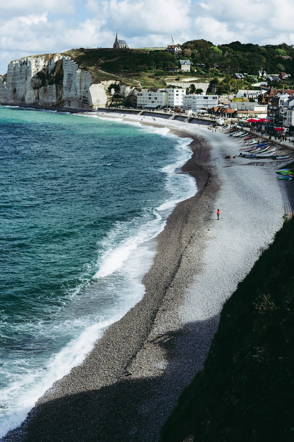 a beach with a cliff and buildings