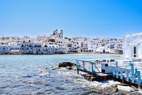 a row of white buildings on a rocky shore