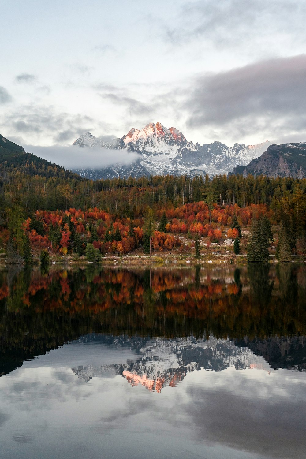 a lake with trees and mountains in the background