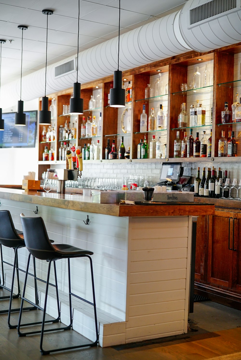 a bar with a large bar and many bottles of alcohol