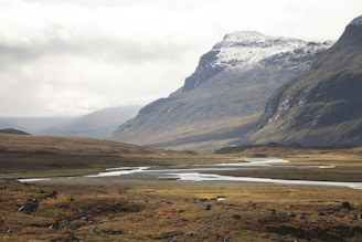 A panoramic view of the game's expansive open world featuring mountains, rivers, and ancient ruins.
