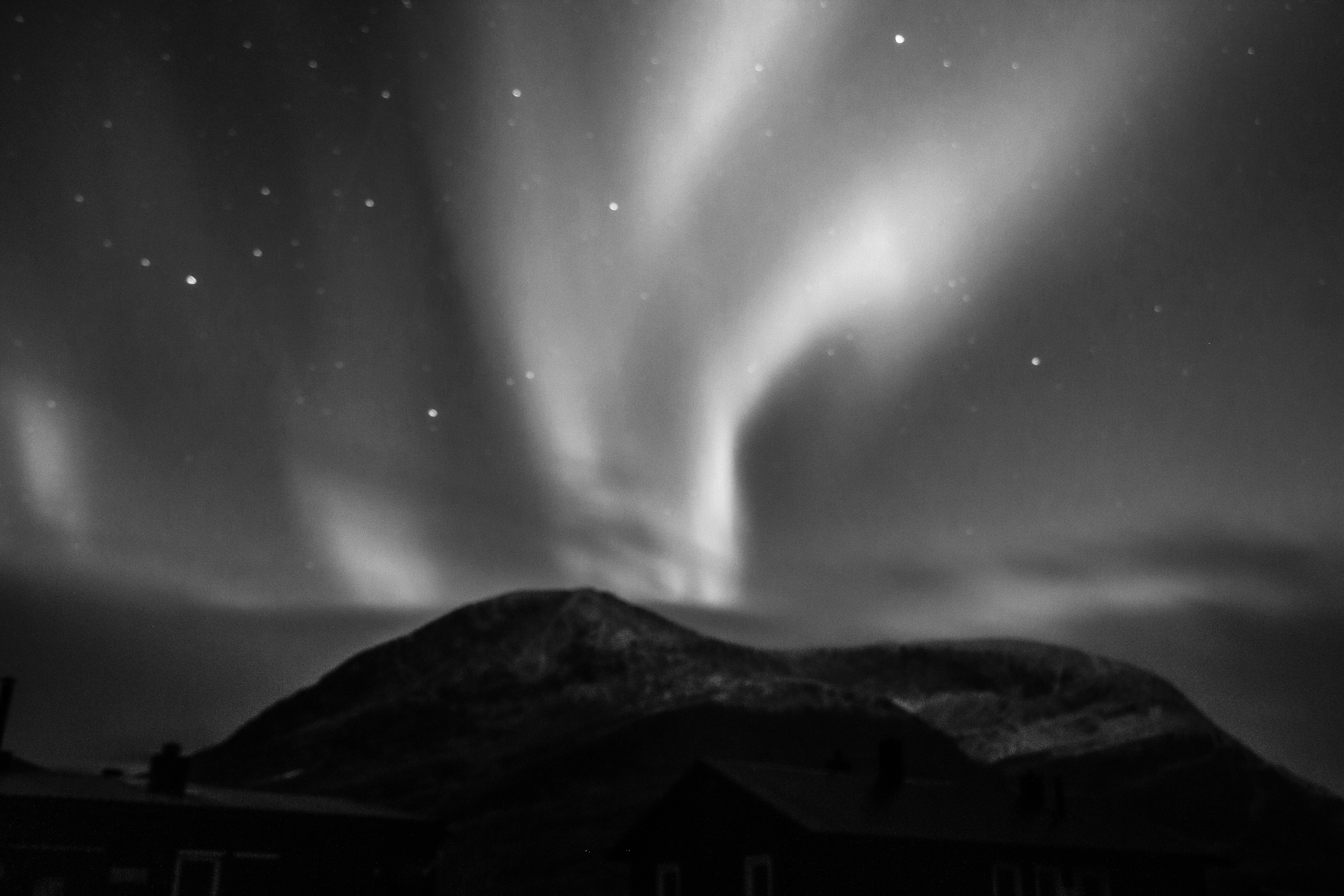 a mountain with a bright light in the sky, 