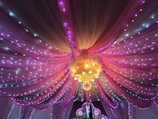 An elegant backdrop featuring draped fabric and fairy lights.