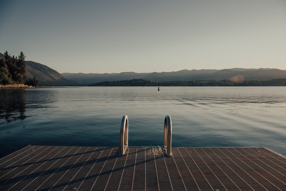 a wood deck over a body of water with a wood deck and trees