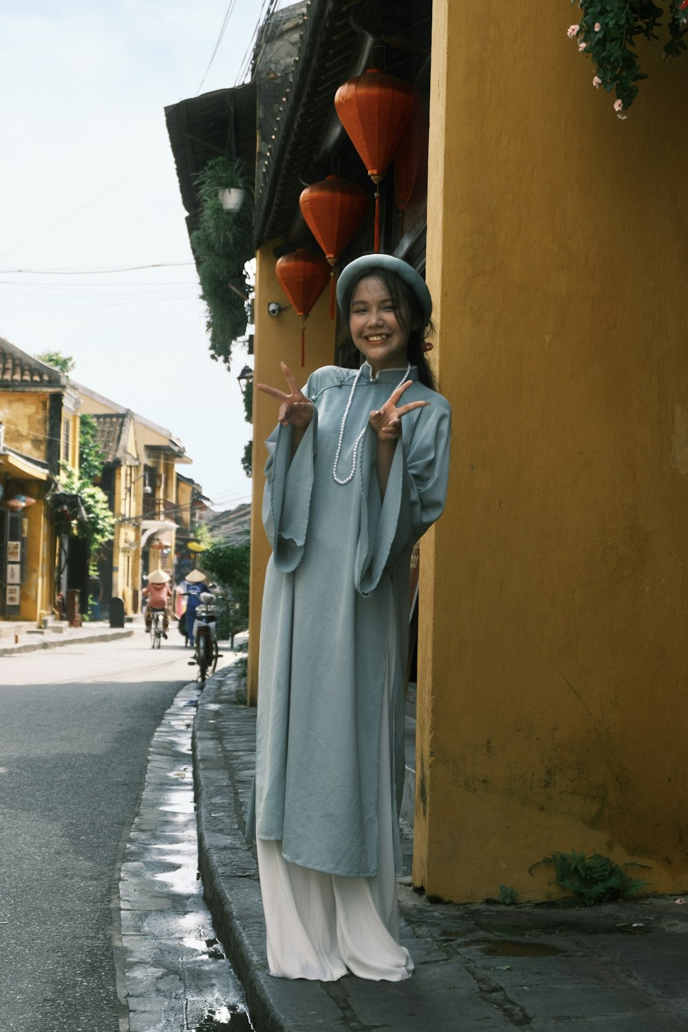 a person in a white dress holding a red object in a doorway